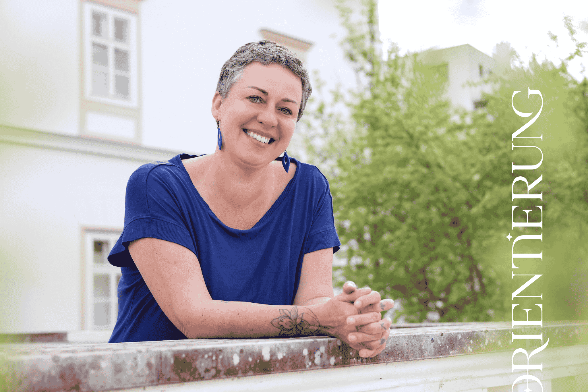 Angela Peichl lehnt mit den Armen auf einer Mauer und lächelt